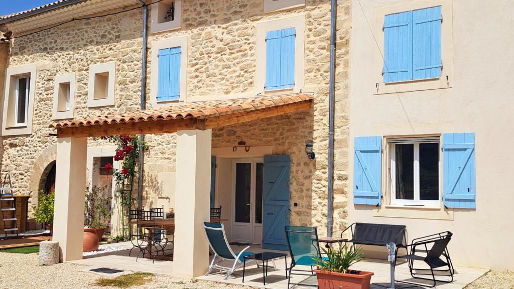 une maison avec des chaises et une table devant elle dans l'établissement Mas la Provinciale, à Malaucène