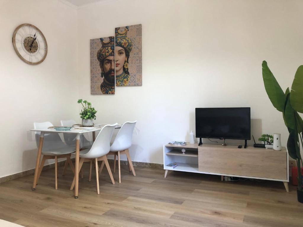 a dining room with a table and a television at Nichi & Matti Iemmolo's Guest House in Campofelice di Roccella