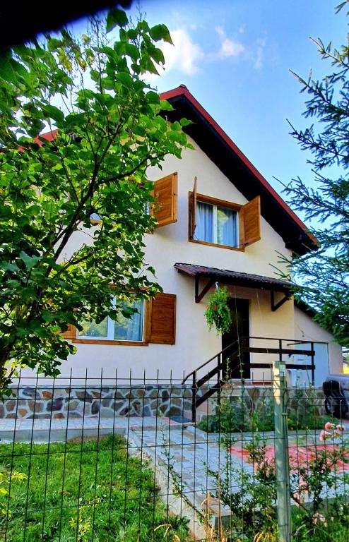 a house with a fence in front of it at Casa Catalyna in Predeluţ