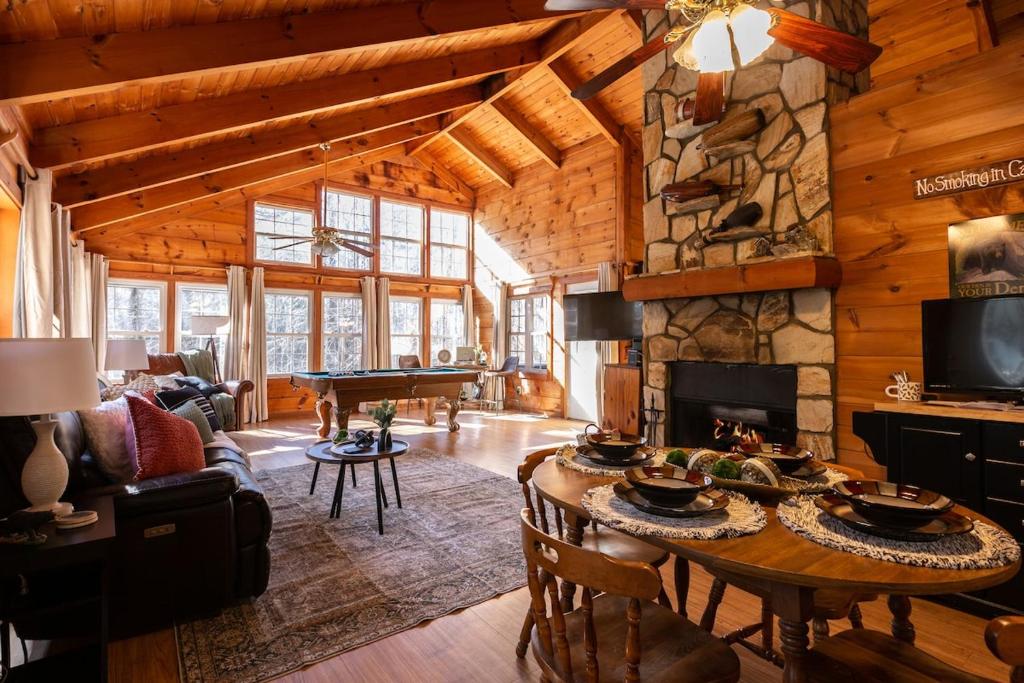 ein Wohnzimmer mit Tisch und Kamin in der Unterkunft Bear's Den Couples Cabin Hot Tub Pets in Sautee Nacoochee