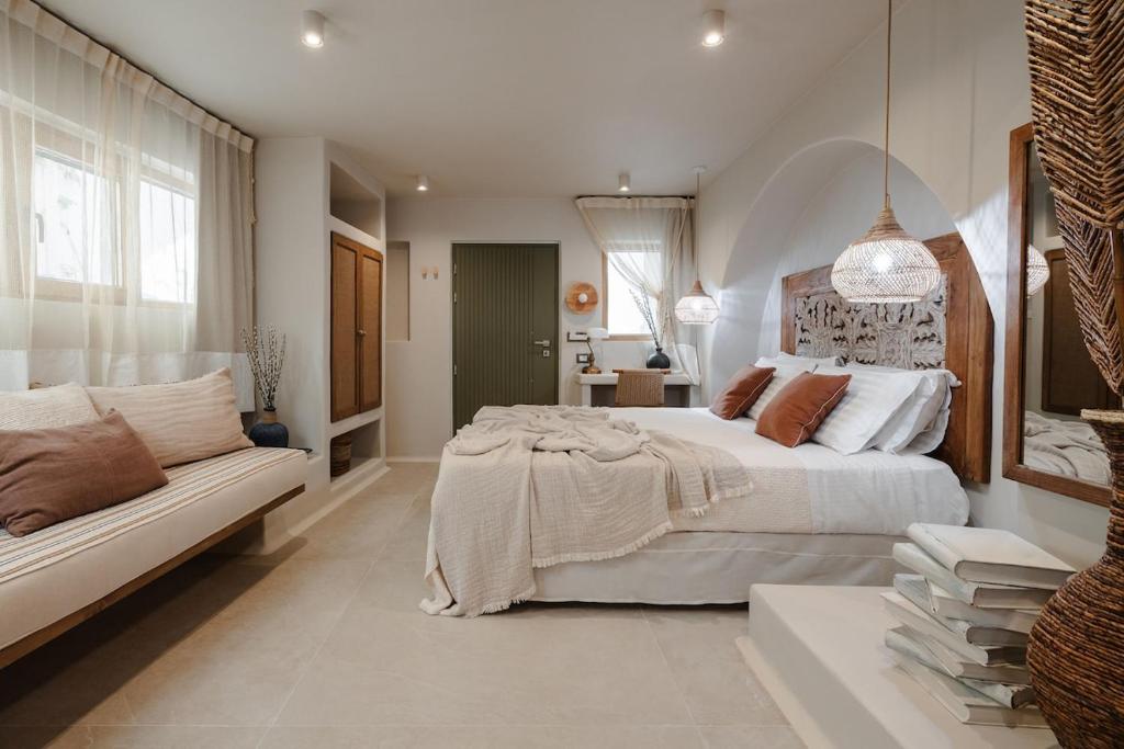 Un dormitorio blanco con una cama grande y un sofá. en Chic Elysium - Serenity, en Naxos Chora