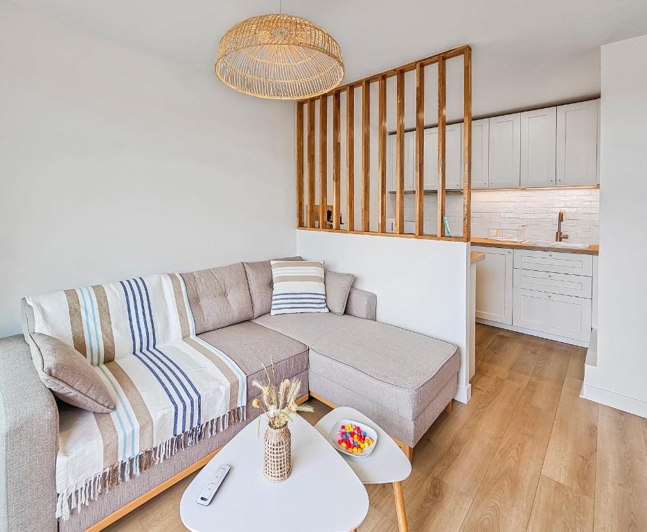 a living room with a couch and a table at South-facing terrace, direct beach access in Cabourg