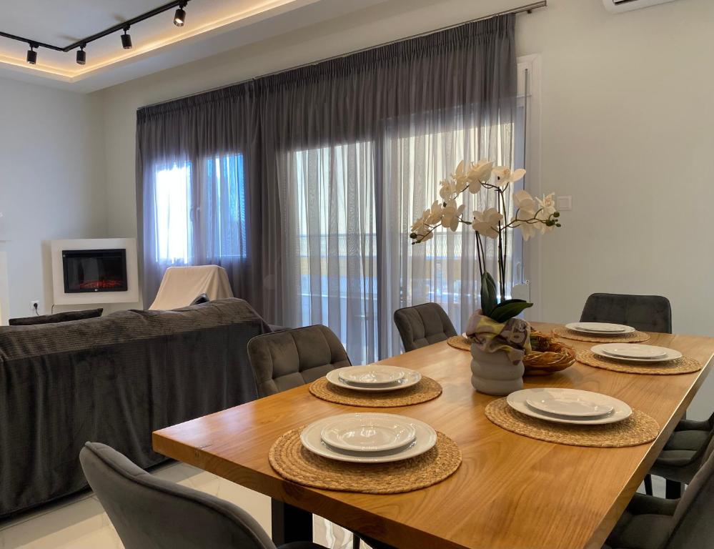 ein Esszimmer mit einem Holztisch und Stühlen in der Unterkunft Angel's Apartment Volos in Volos