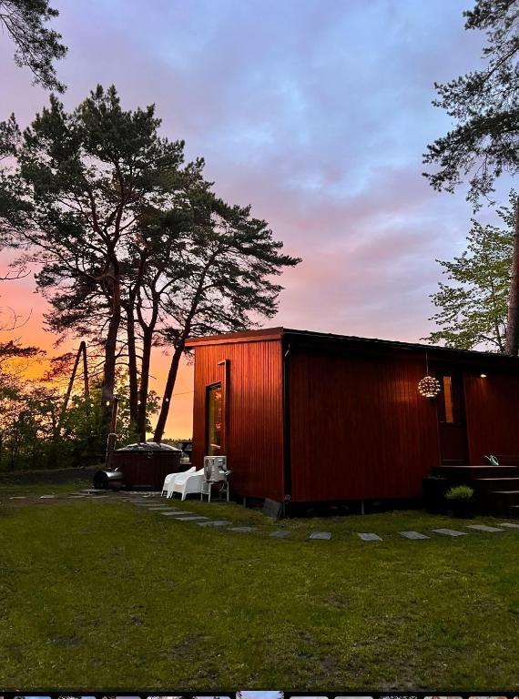 a red shed with a table and a chair in a yard at Pineplace residence in Jūrmala