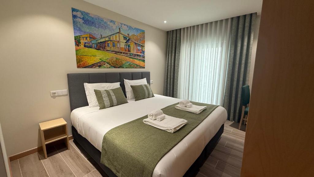 a bedroom with a large bed with towels on it at Oporto Station Hostel & Rooms in Porto