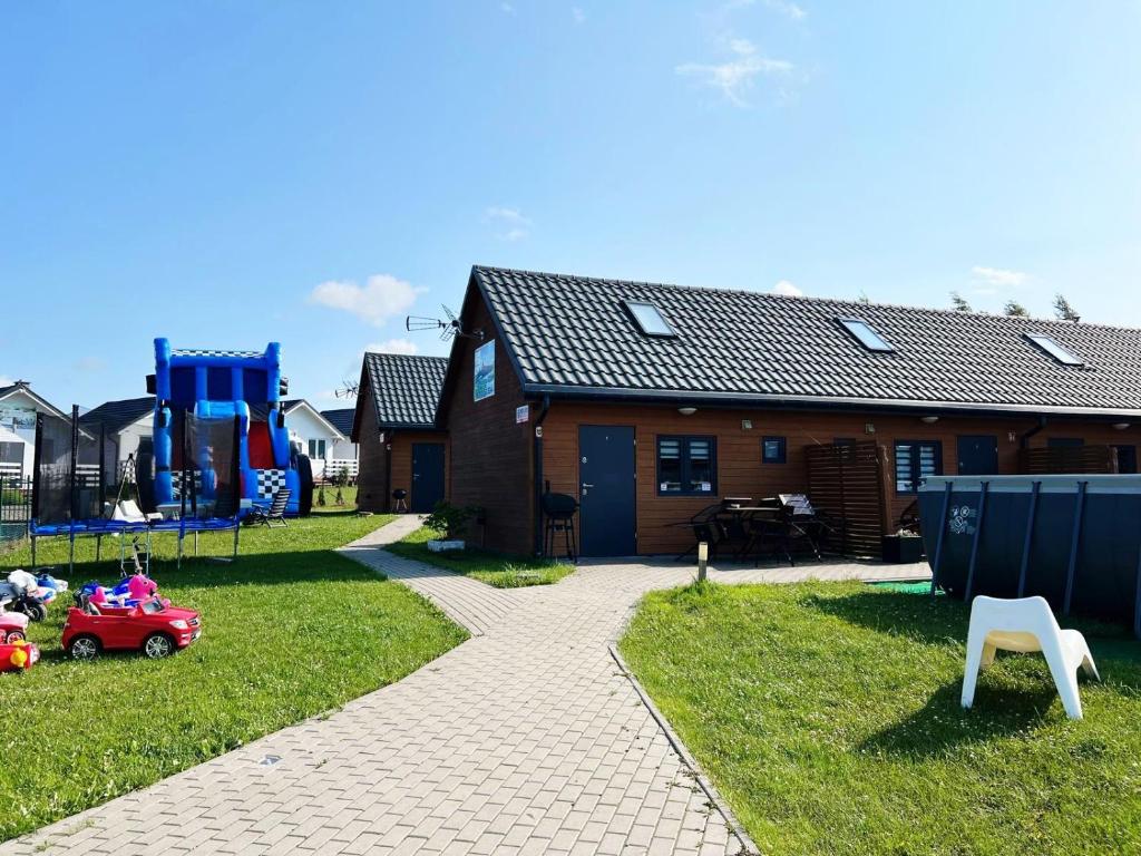 dom z zabawkami w trawie w obiekcie Domki Arkadia Mielno w mieście Mielno