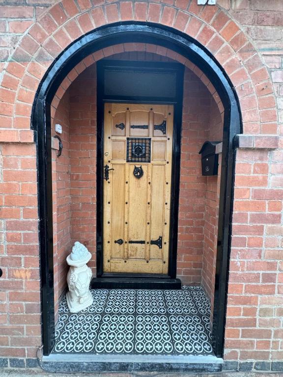 an entrance to a brick building with a wooden door at The Plum Tree - 5 luxury modern bedrooms in Melton Mowbray