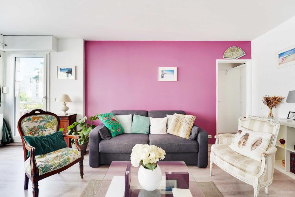 - un salon avec un canapé et un mur pourpre dans l'établissement Charming apartment -1BR-2P- Boulogne-Billancourt, à Boulogne-Billancourt