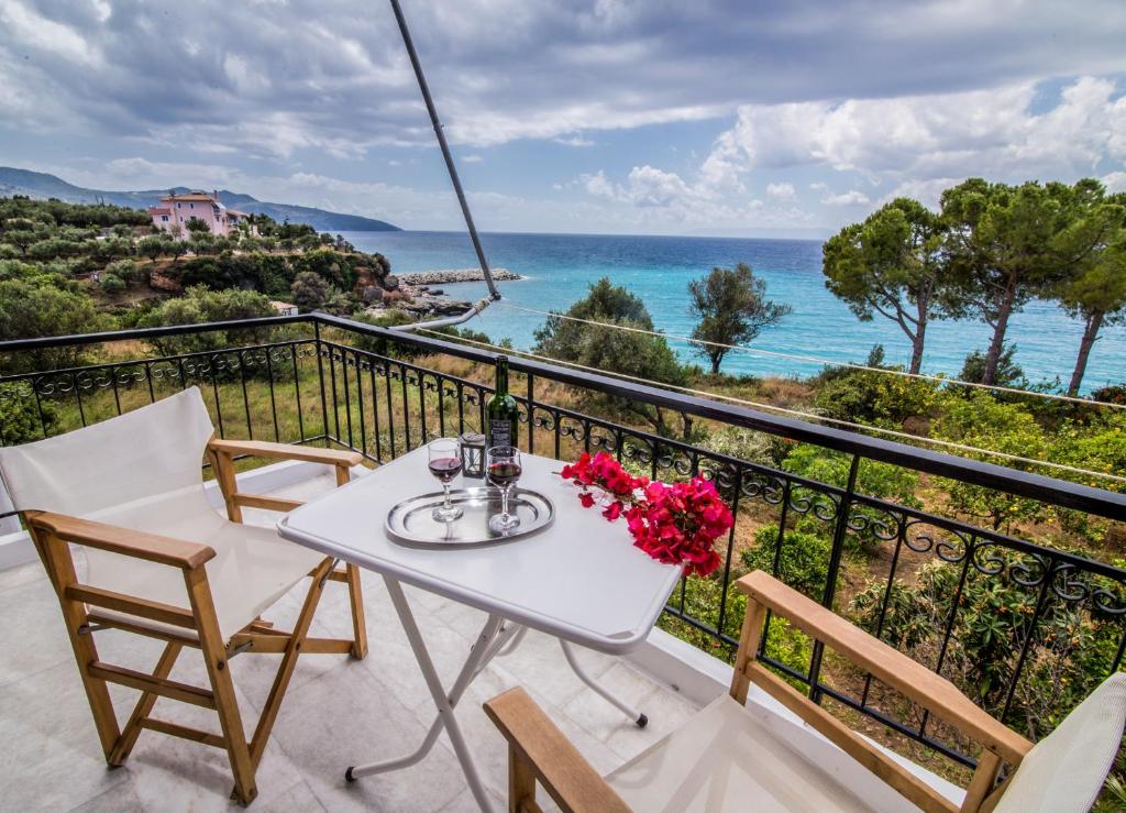 a balcony with a table and chairs and the ocean at Theodora Apartments in Avia