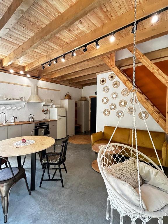 a room with a table and chairs and a kitchen at Szumidomki strefa z jacuzzi sauna widok na potok las in Zawoja