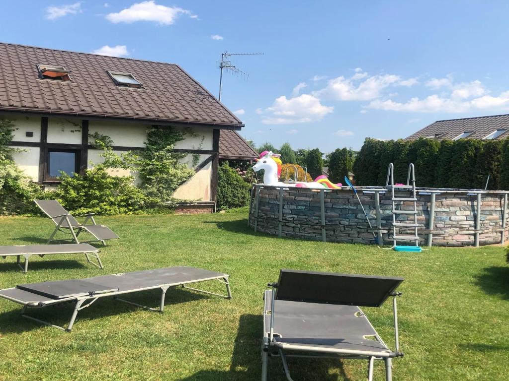 un cortile con due sedie a sdraio e un parco giochi di Comfortable holiday home on Lake Jamno, Podamirowo a Podamirowo