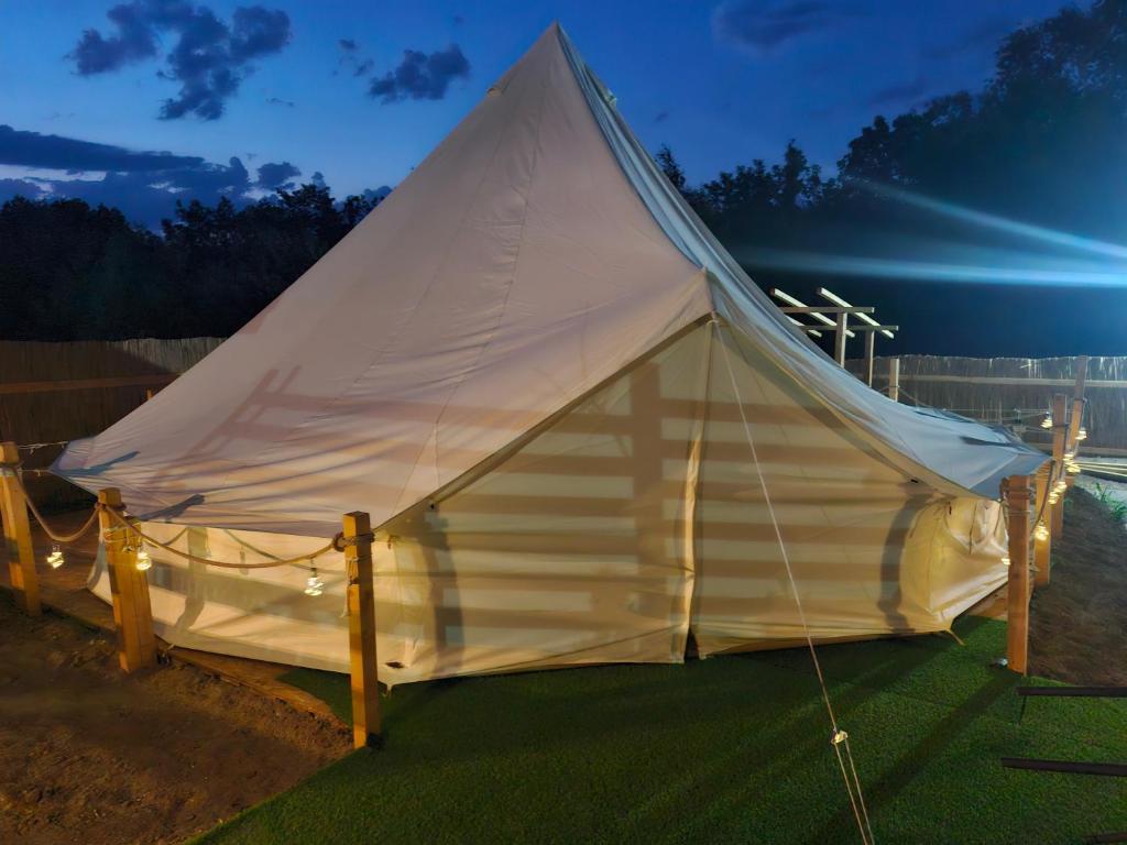 a white tent sitting on the grass at night at Casa Alexia in Potoc