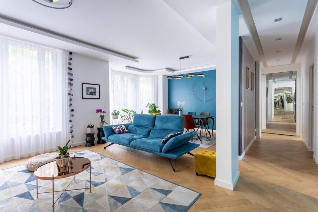 a living room with a blue couch and a table at 4-room apartment Place de la Mairie - City Center in Bois-Colombes