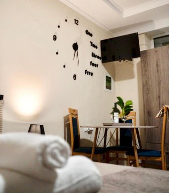 a room with a table and a clock on the wall at Nastas-Home in Igoumenitsa