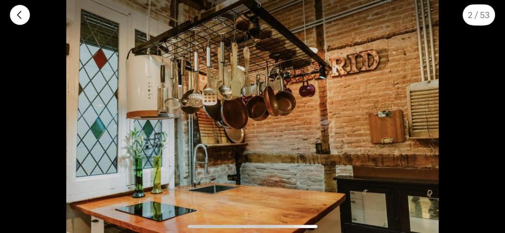 eine Küche mit einem Holztisch und Utensilien in der Unterkunft El antiguo taller de Guantes in Madrid