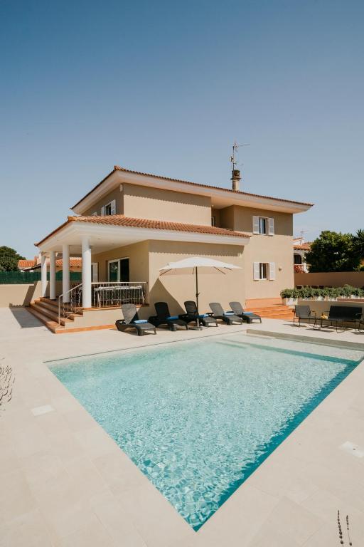 a villa with a swimming pool in front of a house at Villa Victoria Paradise in Cala en Blanes
