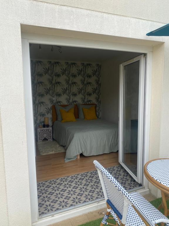 a bedroom with a bed and a patio at Chambre calme in Tremblay En France