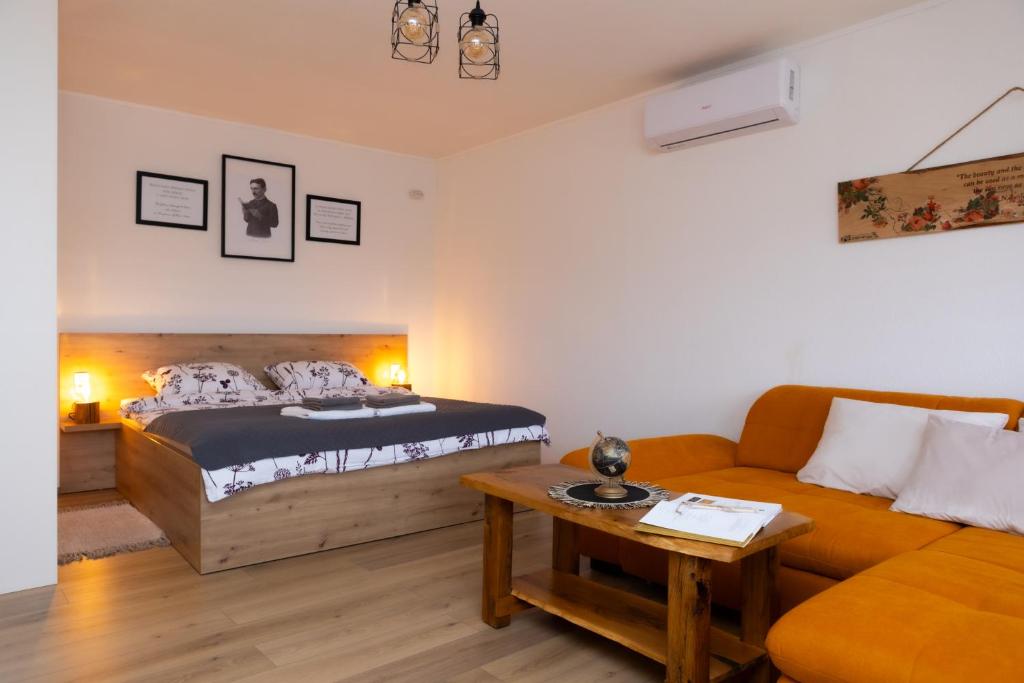 un soggiorno con un letto e un divano di Apartman oak Nikola's lamp a Gospić