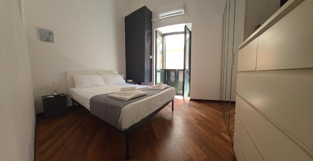 a bedroom with a bed and a large window at La Città Vecchia house Salerno centro in Salerno