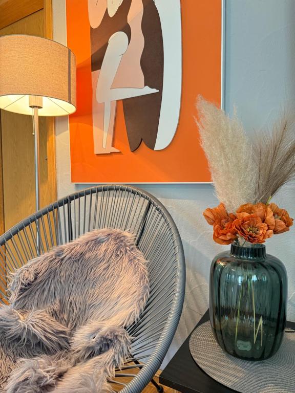 a table with a chair and a vase on it at Apartment Gabriela in Rakovica