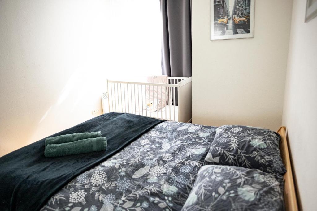 a bed with a black comforter and a green pillow on it at Flat at border suisse in Saint-Louis