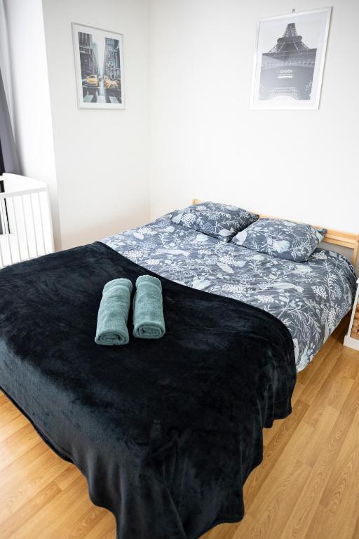 a bedroom with a bed with blue slippers on it at Flat at border suisse in Saint-Louis