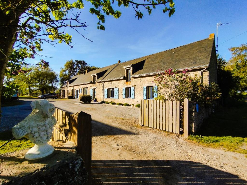 une maison avec une clôture et une statue devant elle dans l'établissement Le clos des Ty, à La Baule