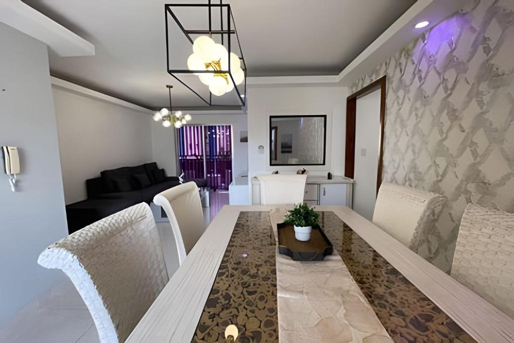 a dining room and living room with a table and chairs at Sunshine Palmares de Caleta in La Romana