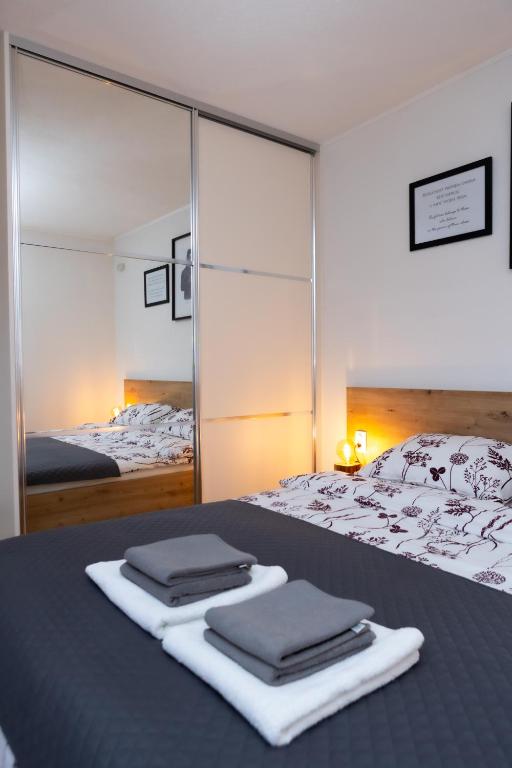a bedroom with a bed with two towels on it at Apartman oak Nikola's lamp in Gospić