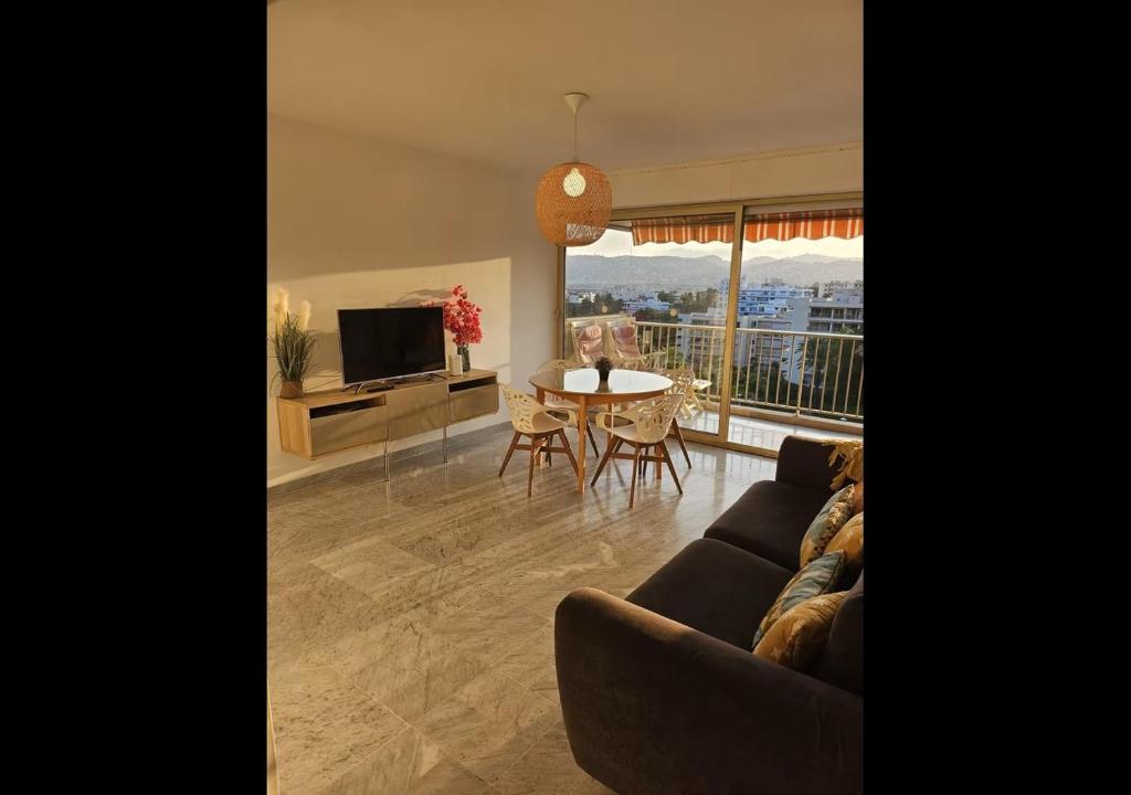 un salon avec un canapé et une table dans l'établissement Vue mer sublime - Piscine & activités sur place, à Juan-les-Pins