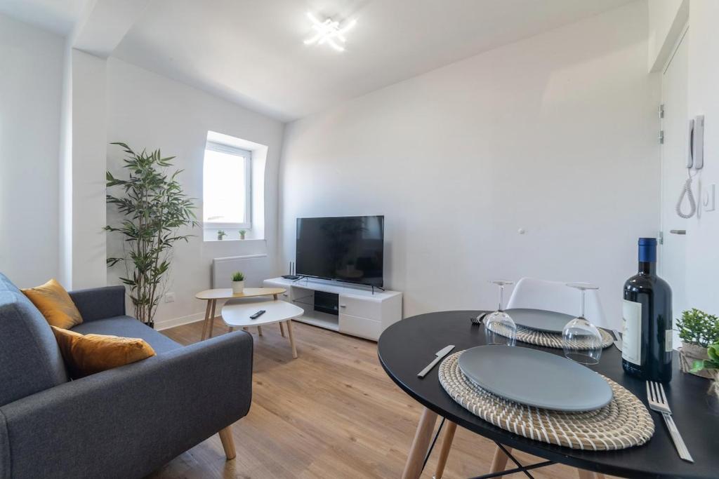 un salon avec un canapé et une table dans l'établissement Le Sweet Plaisancier - Parking and Wi-Fi Gratuits-, à Mulhouse