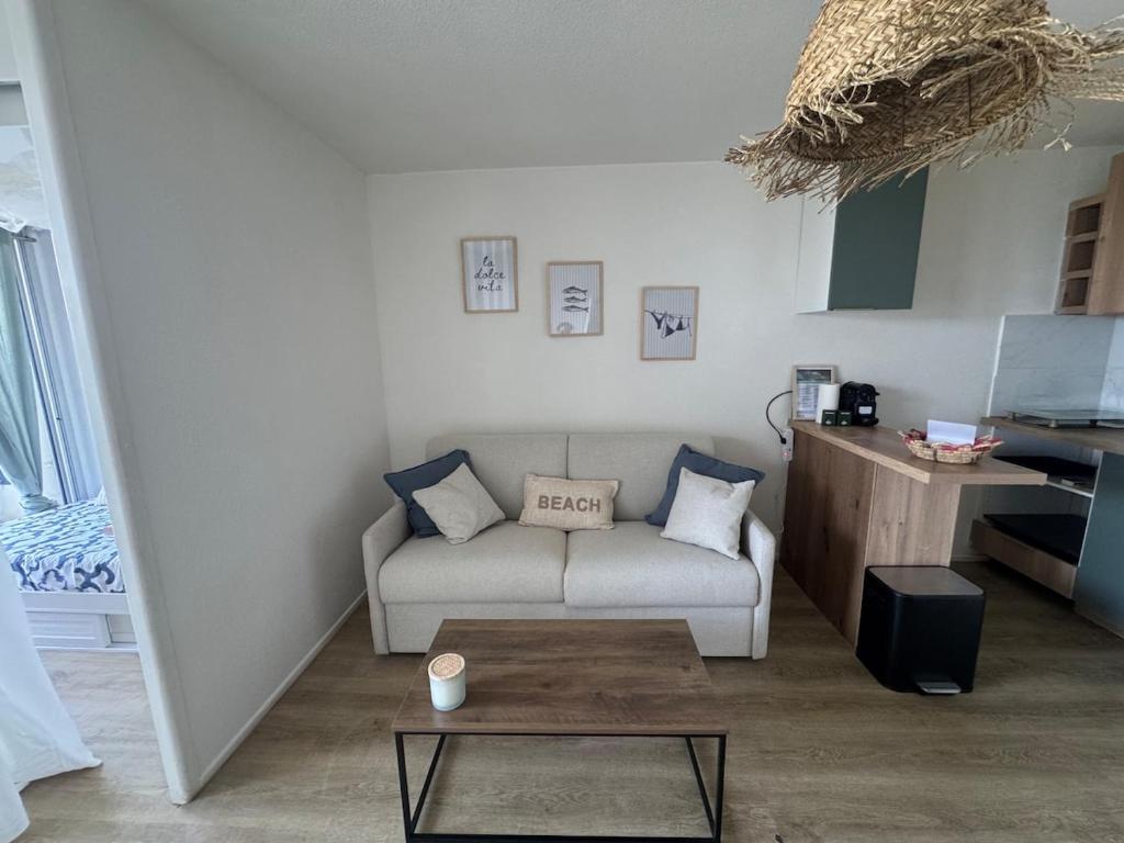 un salon avec un canapé et une table basse dans l'établissement Les pieds dans l'eau - accès mer, à Canet