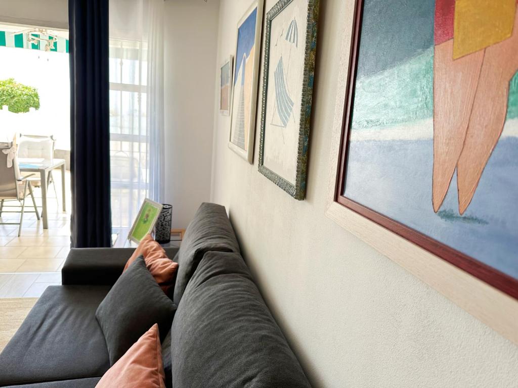 a couch sitting in a living room next to a wall at Relaxing Ocean View, Spacious Art Apartment With Large Terrace, Near Best Costa Adeje Beaches in Adeje