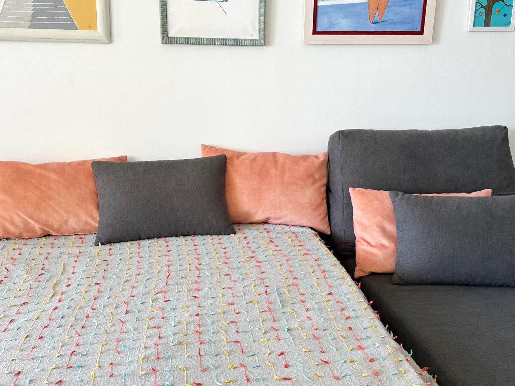 a couch with pillows and a blanket on it at Relaxing Ocean View, Spacious Art Apartment With Large Terrace, Near Best Costa Adeje Beaches in Adeje