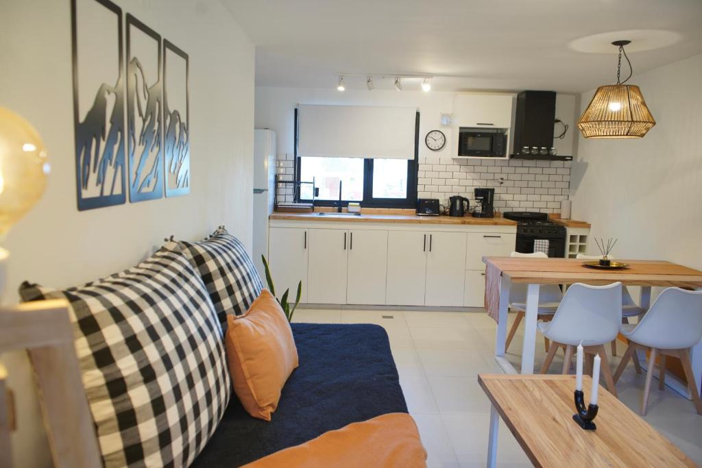 a living room and kitchen with a couch and a table at Los Basaltos departamentos in Caviahue