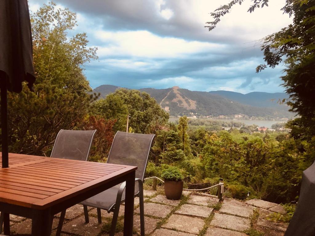 a table and chairs with a view of the mountains at Erdei Kabin Nagymaros in Nagymaros