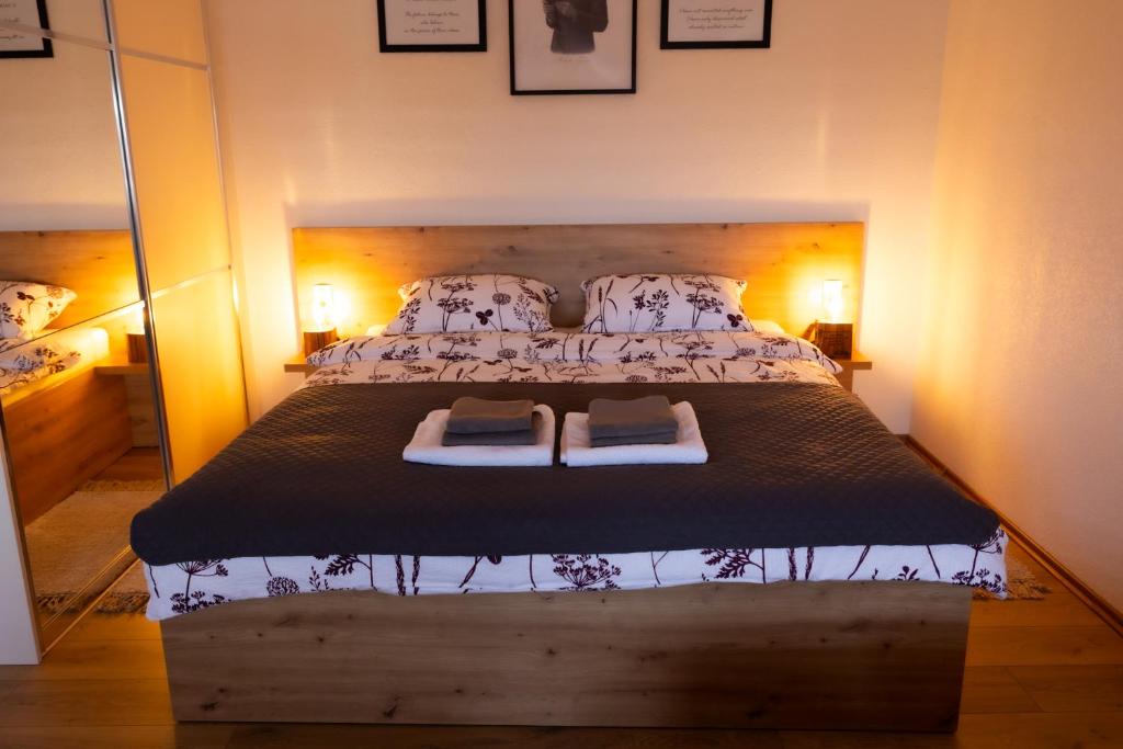 een slaapkamer met een groot bed met twee kussens bij Apartman oak Nikola's lamp in Gospić