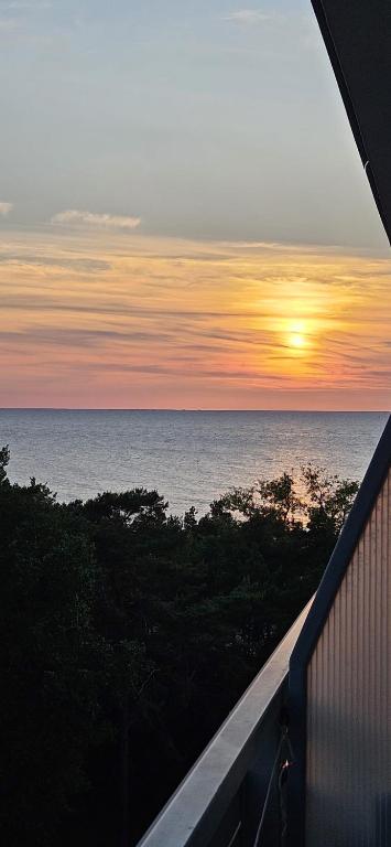 a view of the ocean at sunset from a balcony at Sea View Slavia in Międzyzdroje