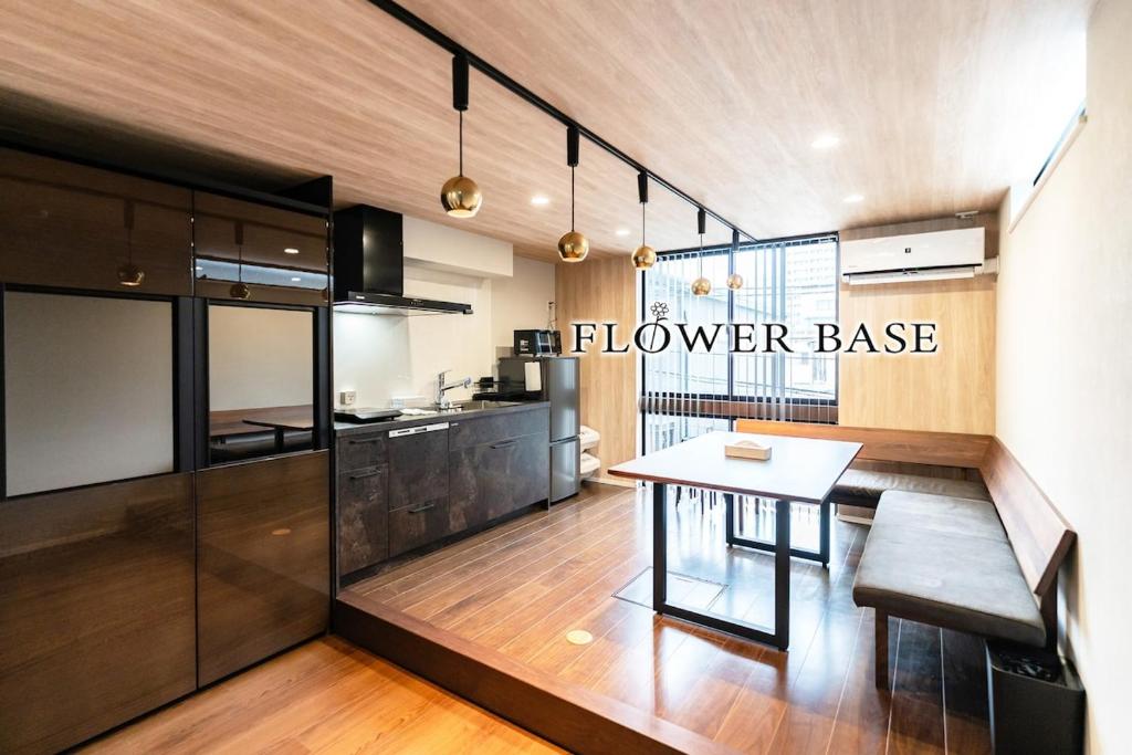 eine Küche mit einem Tisch und einer Küchenzeile in der Unterkunft Flower Base Botan in Fukuoka