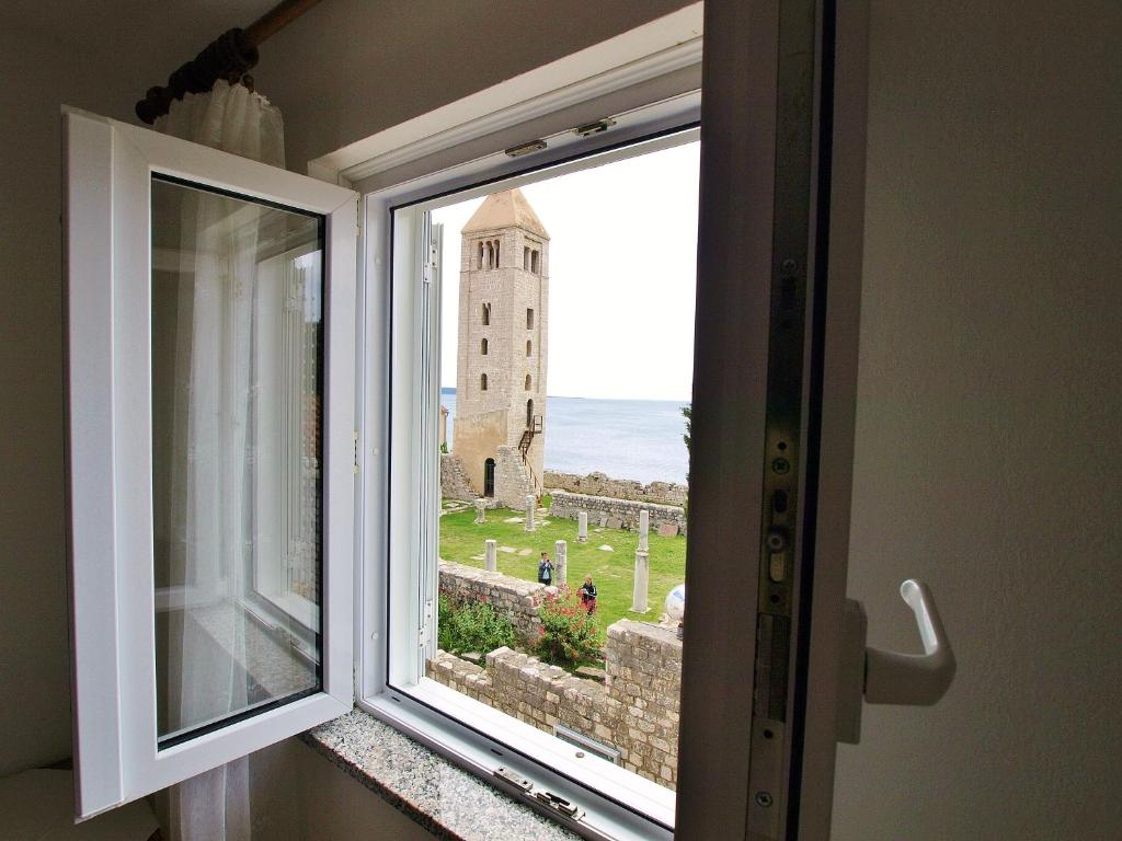 a window with a view of a castle at Apartment Nada in Rab