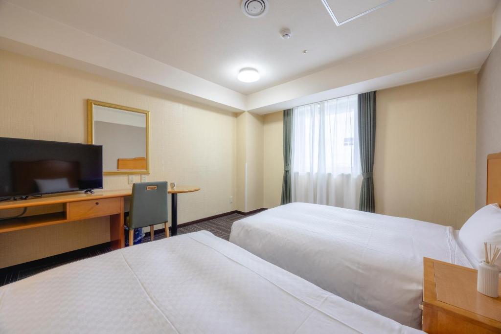 Postel nebo postele na pokoji v ubytování Kanku Izumiotsu Washington Hotel