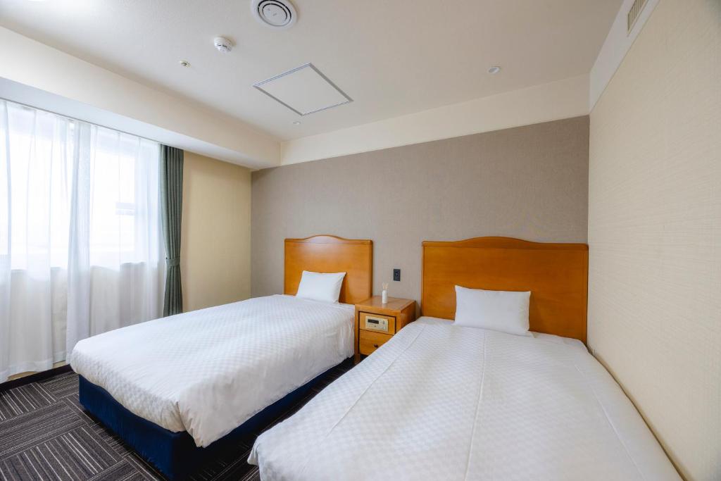 Postel nebo postele na pokoji v ubytování Kanku Izumiotsu Washington Hotel