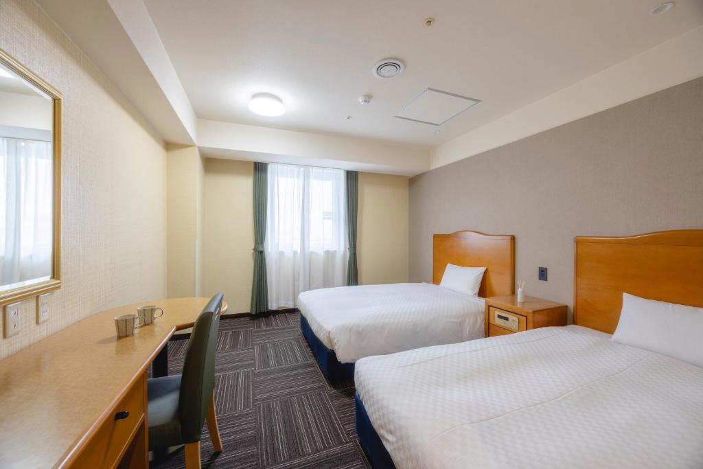 Postel nebo postele na pokoji v ubytování Kanku Izumiotsu Washington Hotel