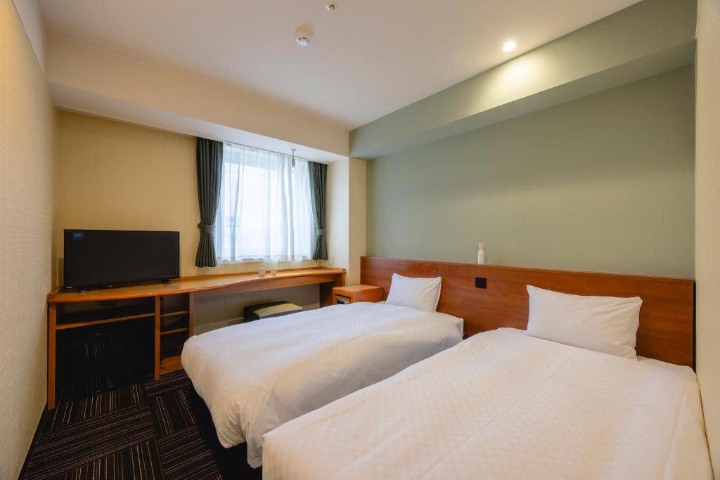 Postel nebo postele na pokoji v ubytování Kanku Izumiotsu Washington Hotel