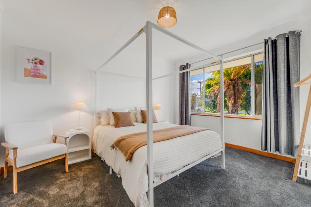 una camera da letto con letto a baldacchino e finestra di The sweet and spicy retreat a Mount Gambier