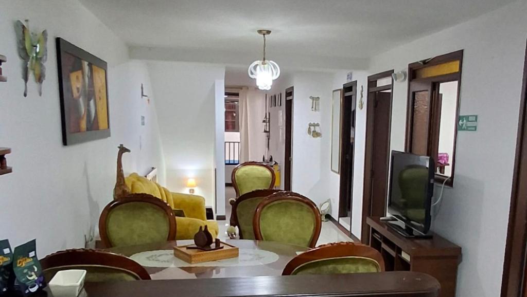 a living room with a table and chairs and a tv at Apartamento central - Villa Xiomara in Santa Rosa de Cabal