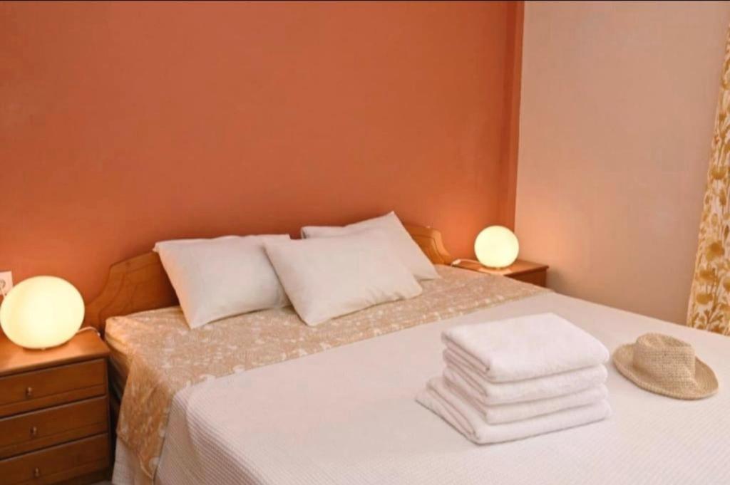 a bedroom with a bed with two lamps and towels at Appartement entier in Paralia Katerinis