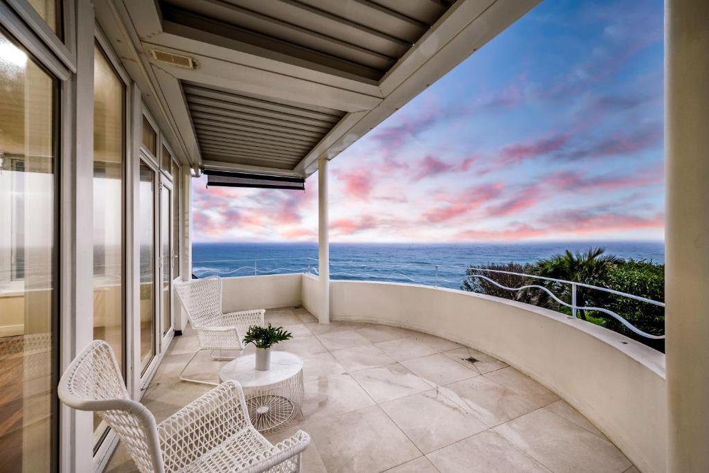 a balcony with chairs and a view of the ocean at Coastal Dream BeachFront Oasis in Newcastle