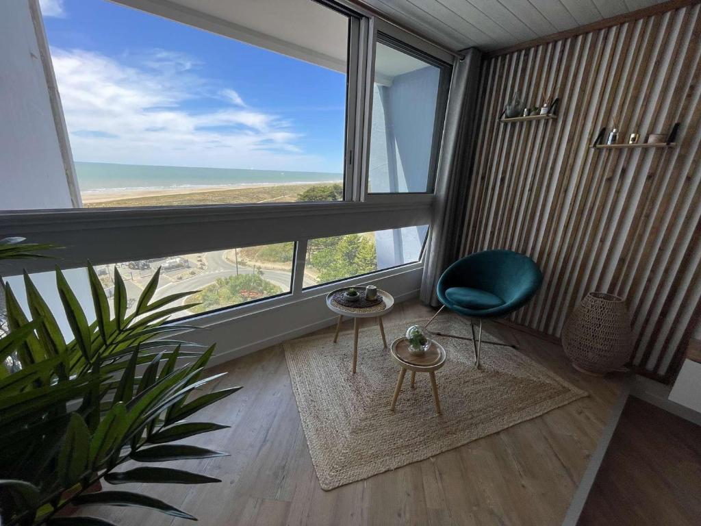 Cette chambre dispose d'une chaise verte et d'une grande fenêtre. dans l'établissement Appartement moderne 2 pièces avec parking à Saint-Jean-de-Monts - FR-1-224C-352, à Saint-Jean-de-Monts