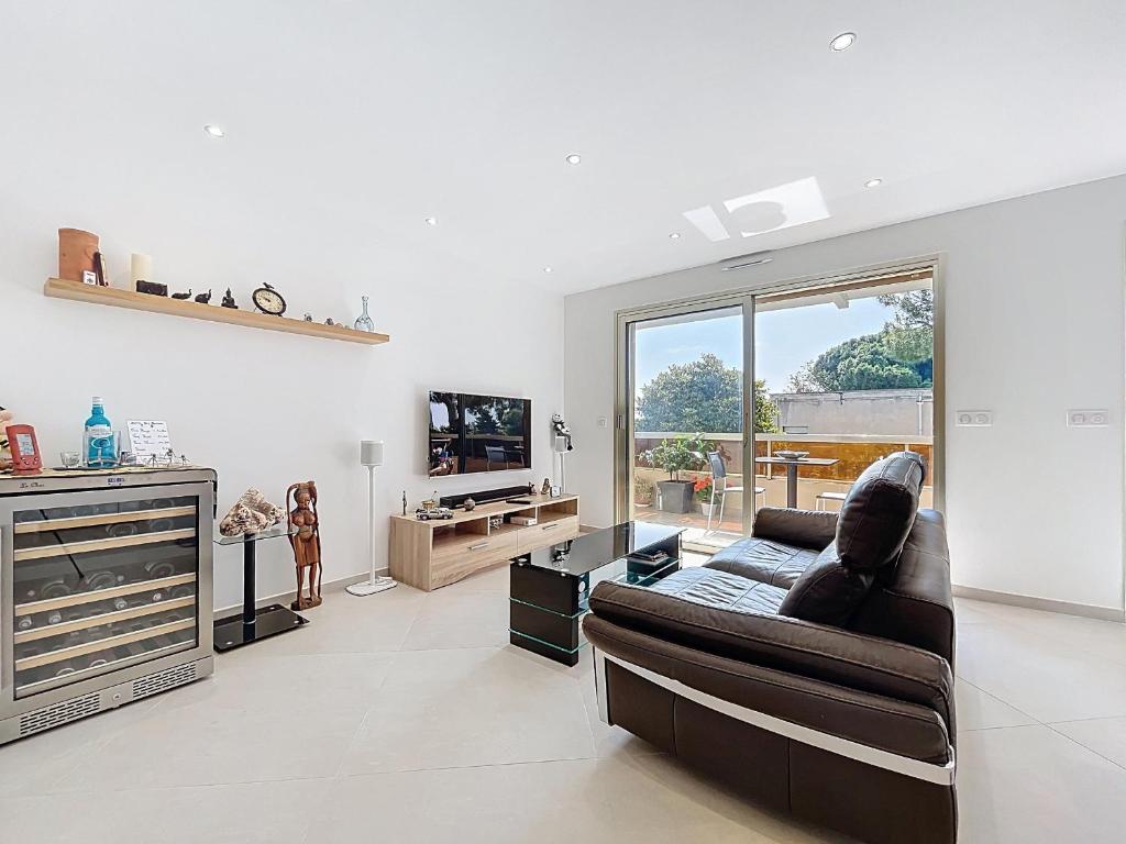 un salon avec un canapé et une télévision dans l'établissement Appartement de Charme, Climatisé - Antibes - FR-1-789-11, à Antibes